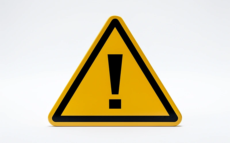 Segnale di attenzione giallo su sfondo chiaro